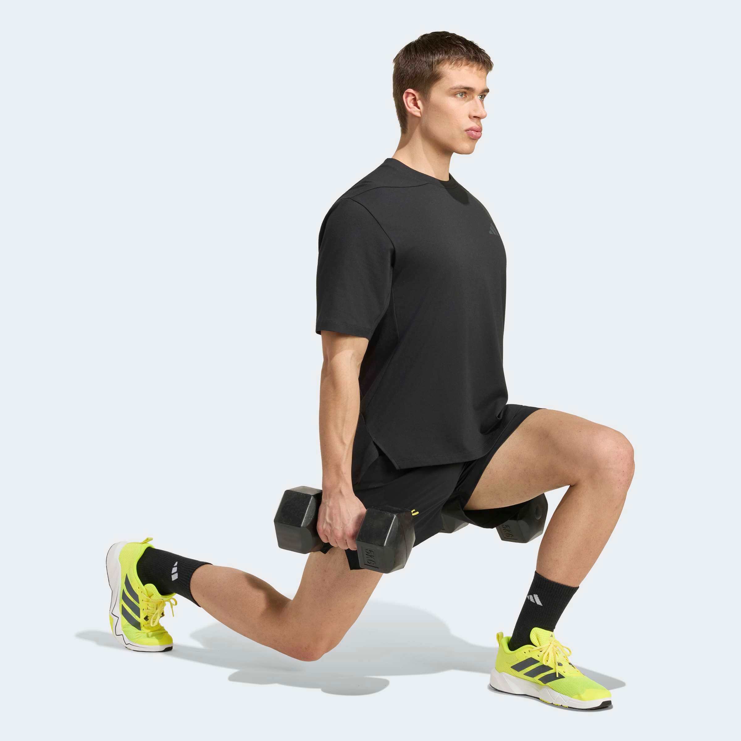 Мъжка тренировъчна тениска Adidas PrimeLift Essentials KG9016 в черно, показана по време на упражнение с дъмбели