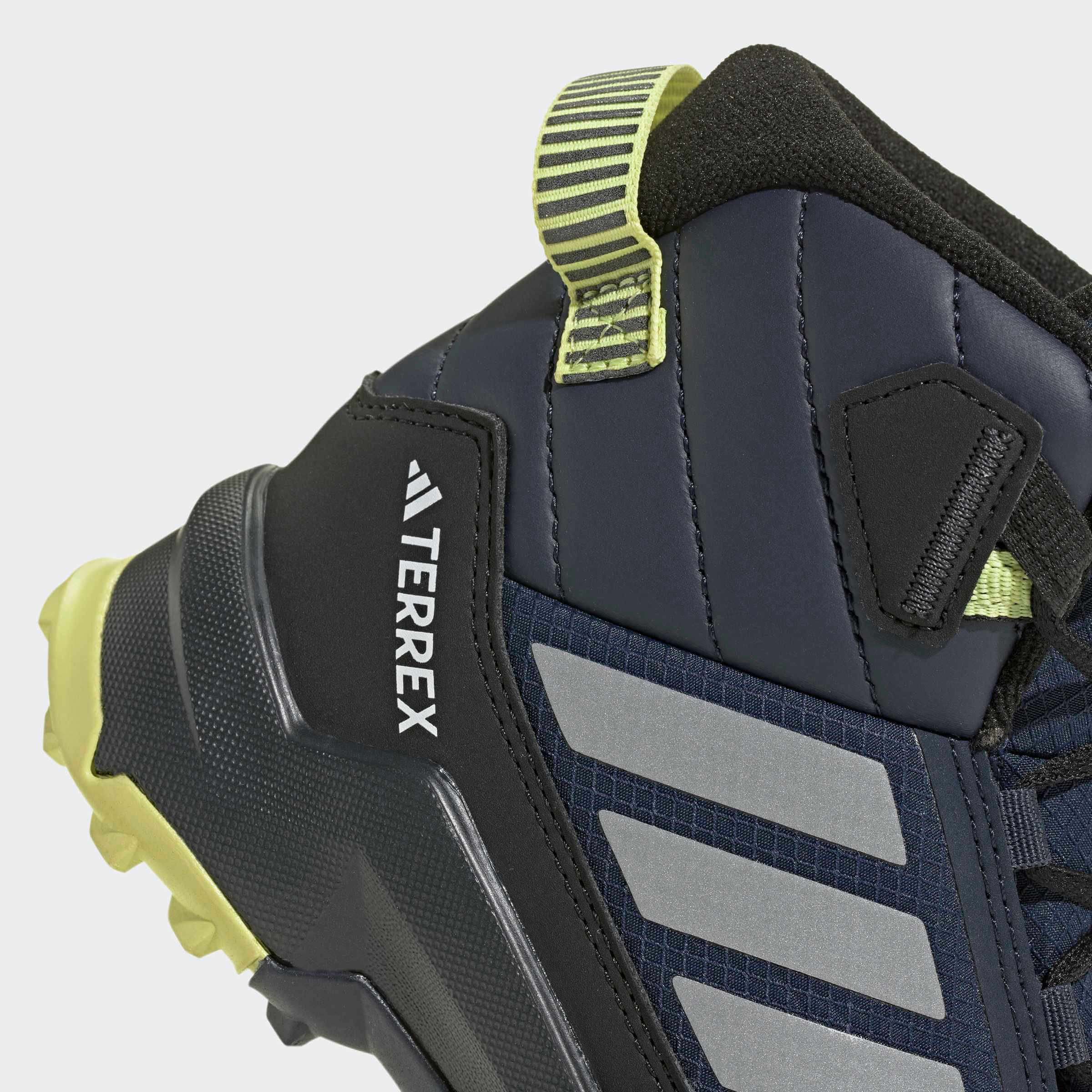 Детски зимни боти adidas Terrex AX4R – детайл на подплатата около глезена, подсилената пета и светлозелената примка